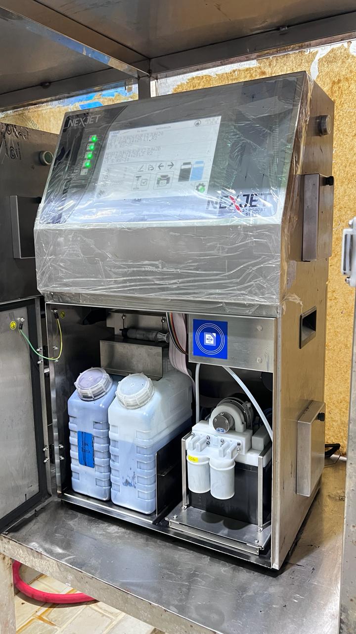NexJet CIJ ink and solvent bottles in open cabinet